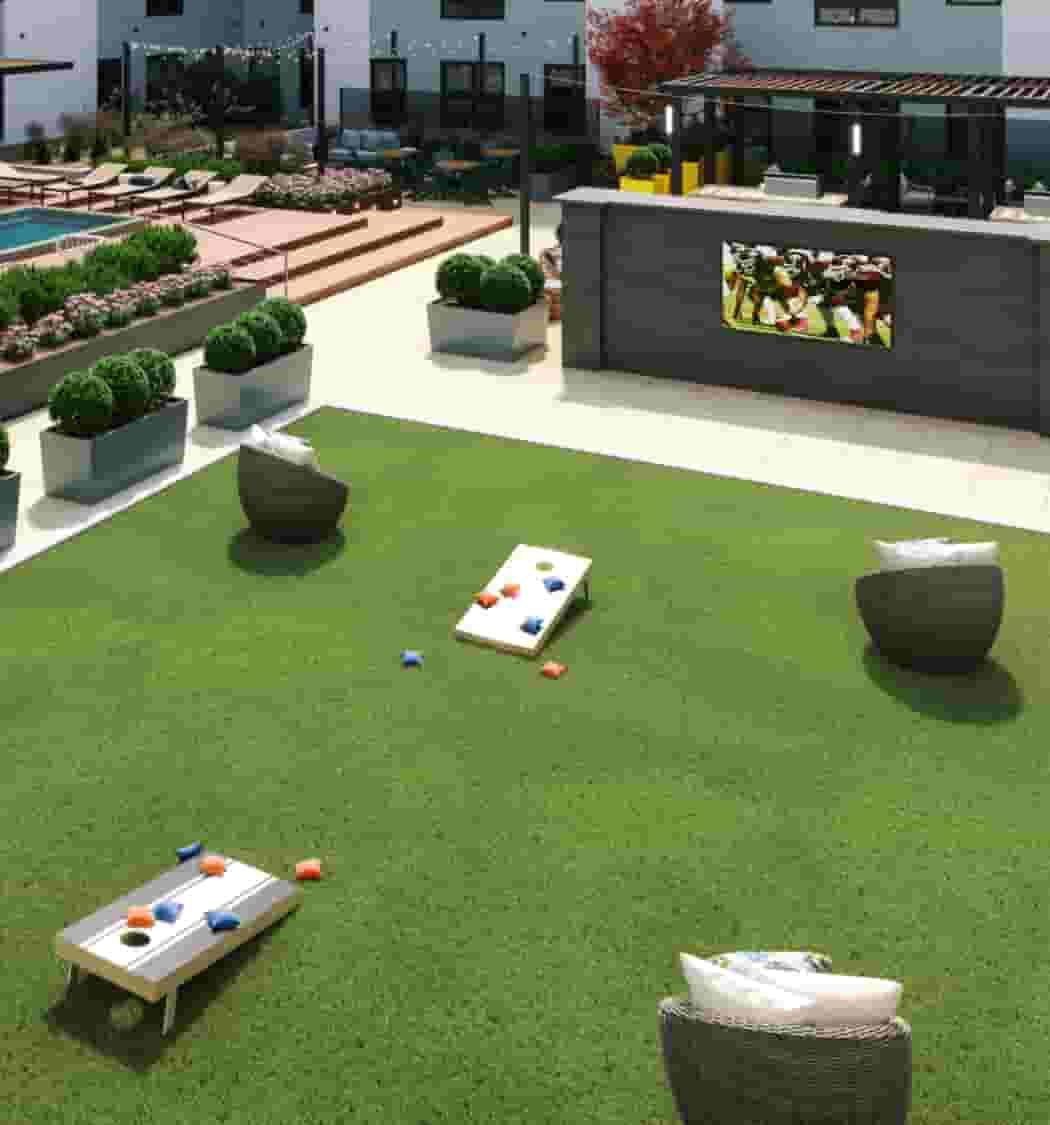Courtyard with outdoor TV, greenspace, games, grilling, lounge seating, and lush landscaping